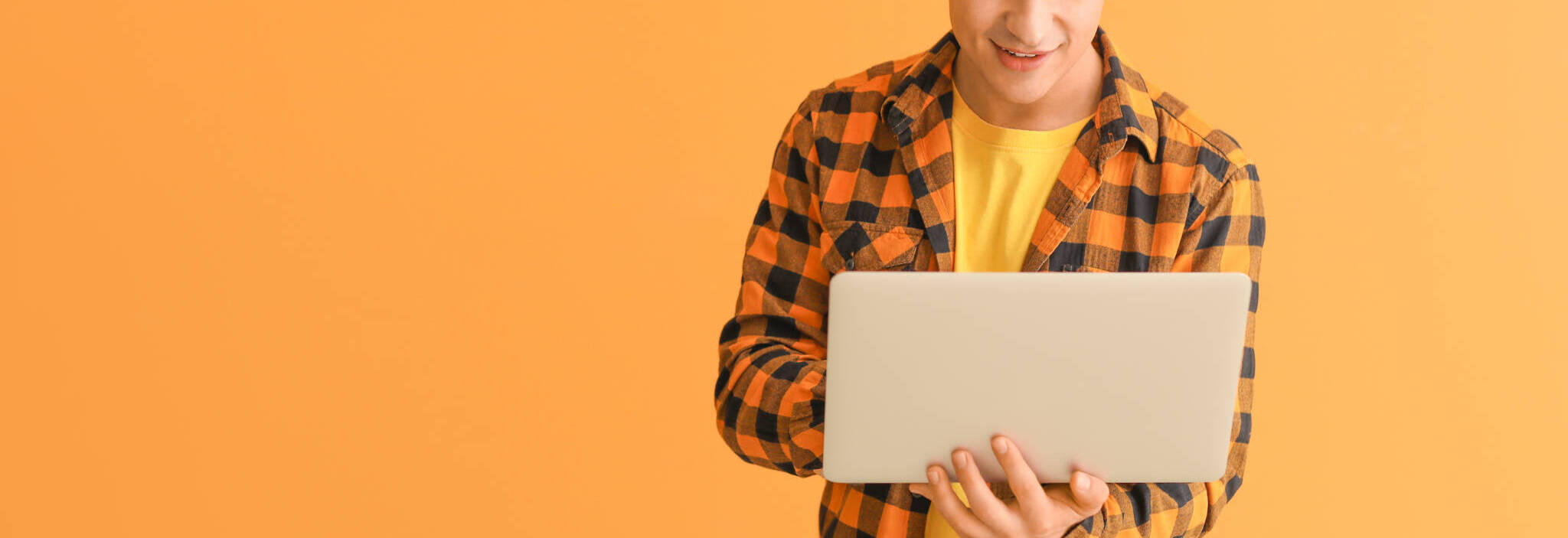 Young Man With Laptop Checking His E Mail On Color Background